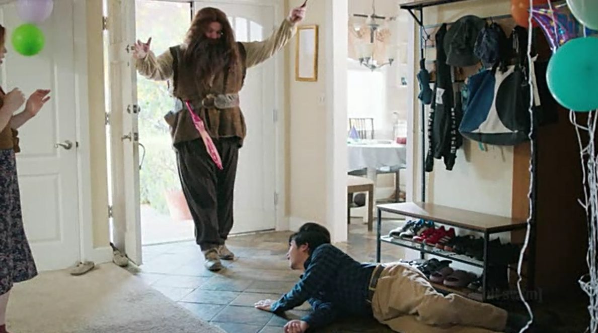A man dressed as Hagrid bursts through the front door while David lies on the floor