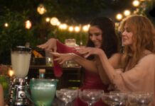 “Practical Magic 2” Review: Sandra Bullock and Nicole Kidman Still Have the Sauce Sandra Bullock and Nicole Kidman in Practical Magic 2 (2026) in elegant dresses joyfully dance while preparing drinks at a festive outdoor gathering, surrounded by blurred lights and festive decor.