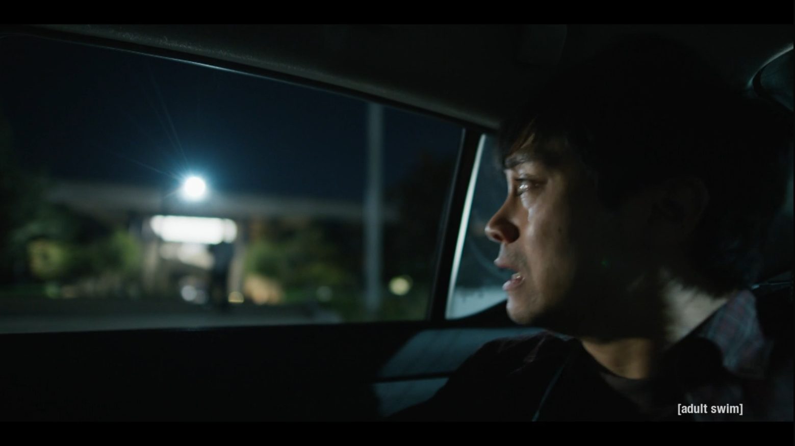 Jordan Mendoza catching his breath in the back seat of a car at night.