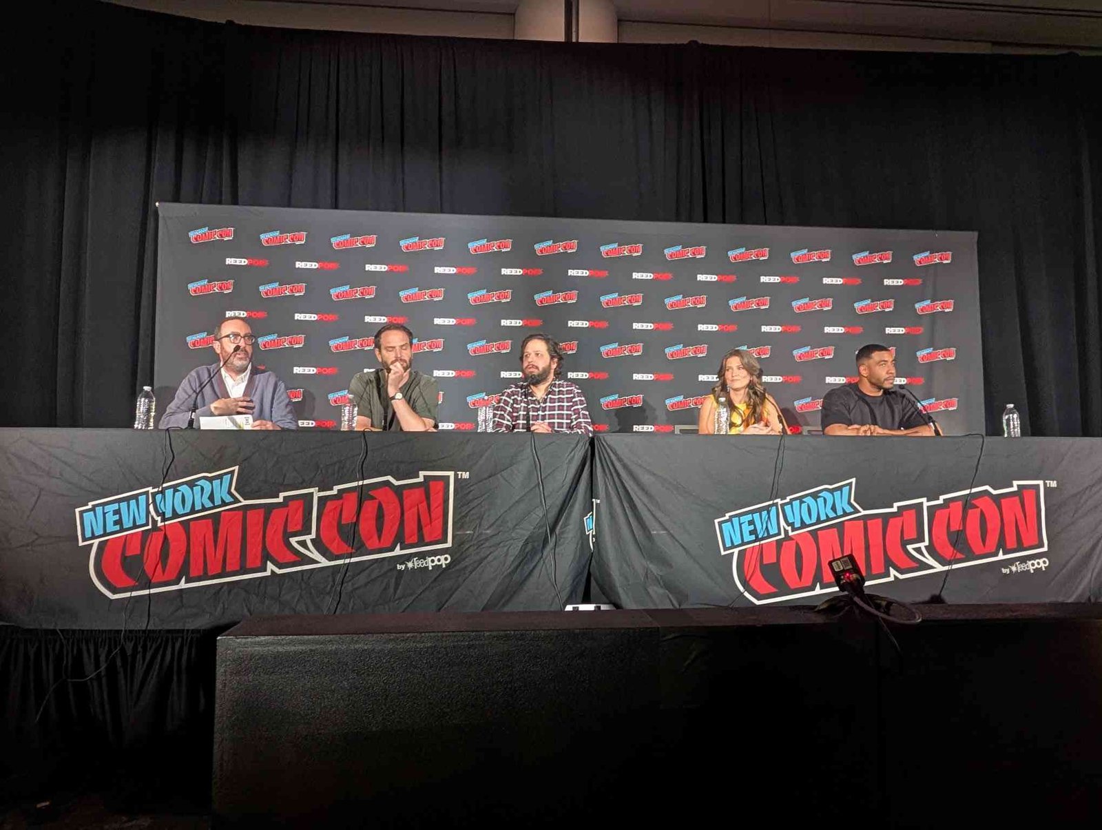 Common Side Effects co-creators and voice cast seated at the NYCC 2026 panel table