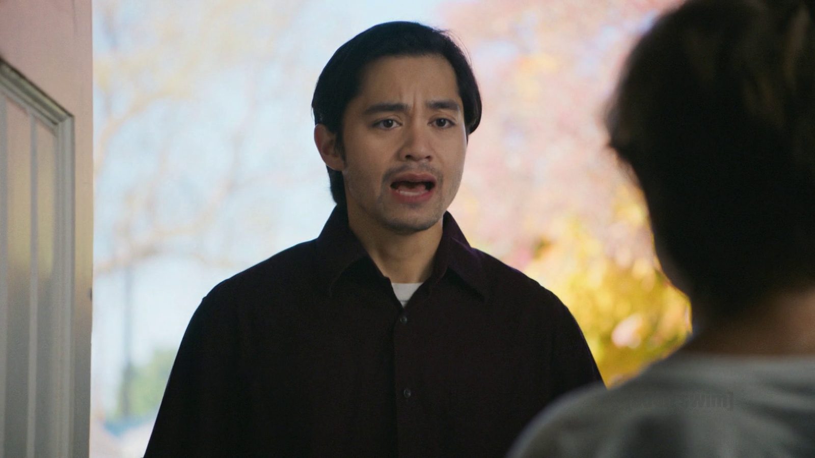 Jordan Mendoza mid-impression in a doorway while a young boy stares at him blankly