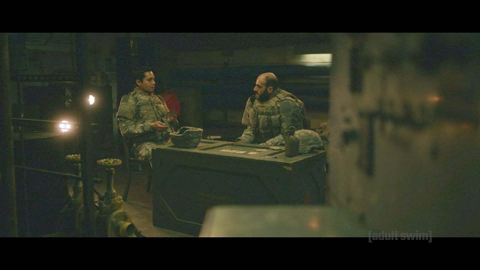 Two soldiers playing cards in a tent in the flashback scene